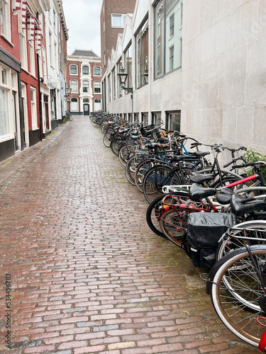 Many parked bicycles near building on city street