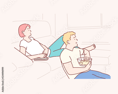 Smiling couple relaxing and watching TV at home, eating popcorn, having rest after hard week. Hand drawn style vector design illustrations.