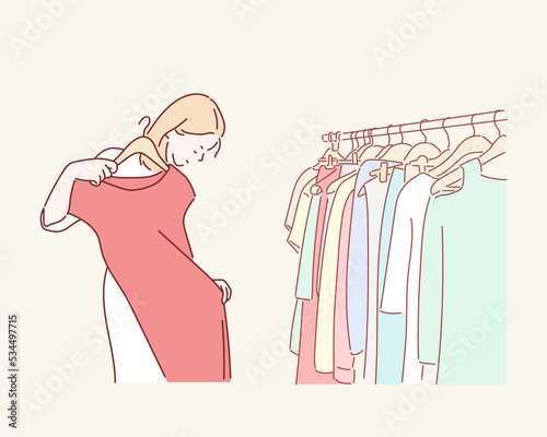 Young woman choosing blouse in the clothes shop. Hand drawn style vector design illustrations.