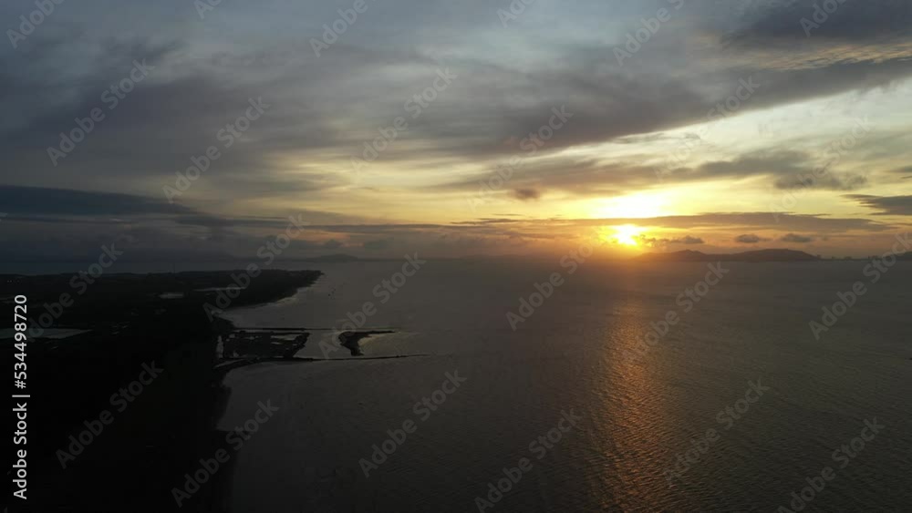 Aerial panning view of sunrise over coast and water with colorful moving clouds in Can Gio, Vietnam Aerial panning view of sunrise over coast and water with colorful moving clouds in Can Gio, Vietnam