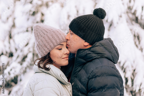 Young couple in love hugging in the winter forest and having fun spending time together.Winter,Valentine's day,newlyweds, tenderness and love.