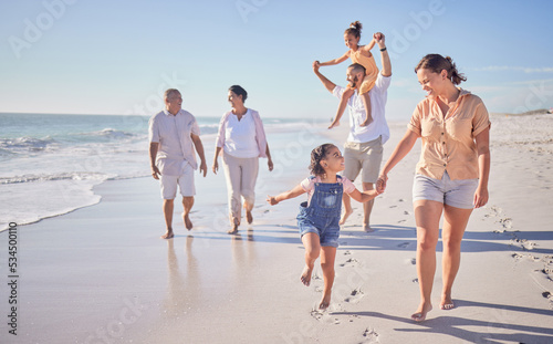 Family, beach and happy in cancun vacation in summer with smile, laugh and love together walking on the sand. Laugh, bonding and chasing joy while men, women and kids playing on holiday travel photo