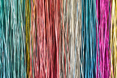 Many colorful prepared threads for weaving close up background