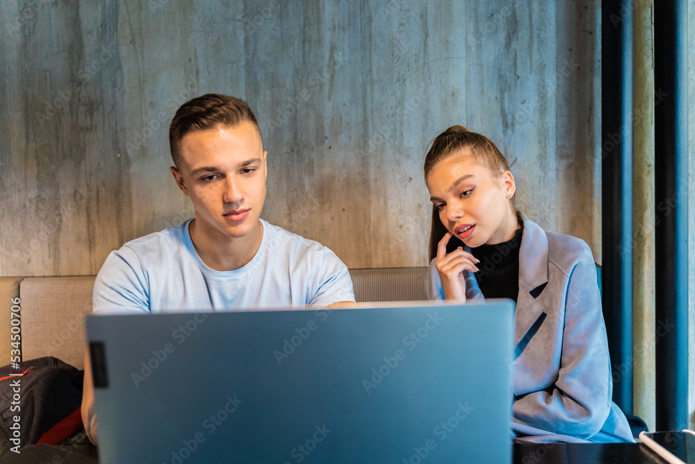 Smiling together and sitting while looking at the lap top Smiling together and sitting while looking at the lap top