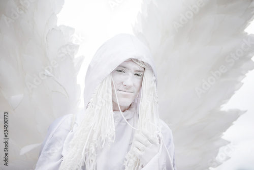 A man in a white angel costume with wings close-up.Gothic white angel.