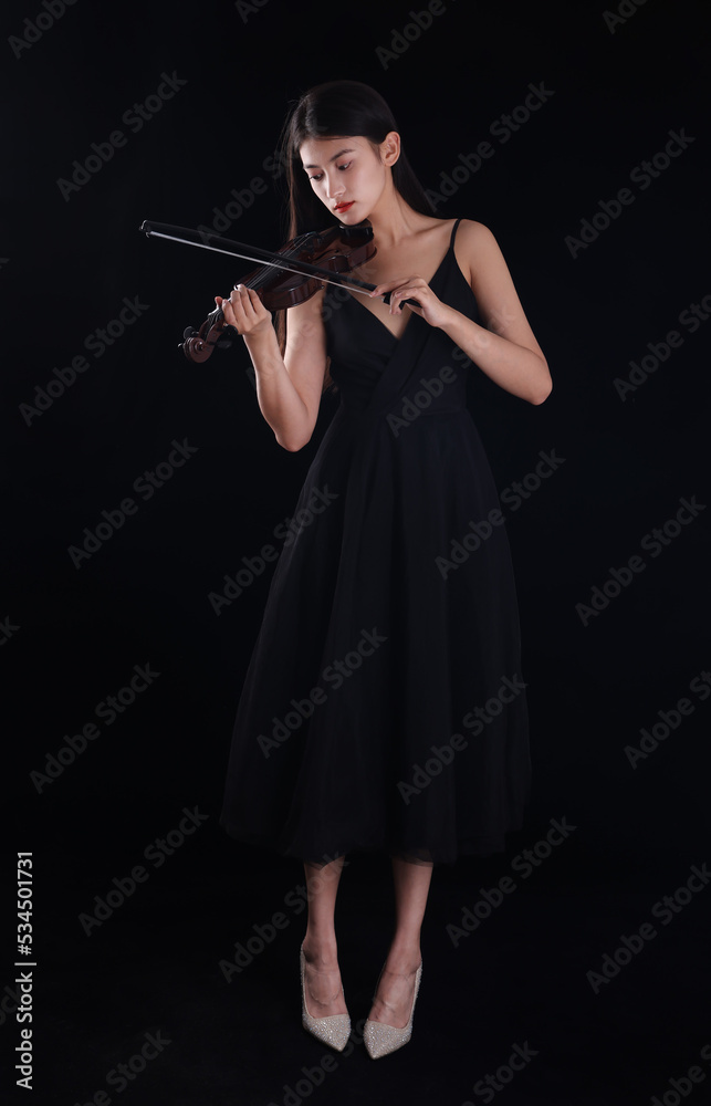 A young woman playing a violin on a black background