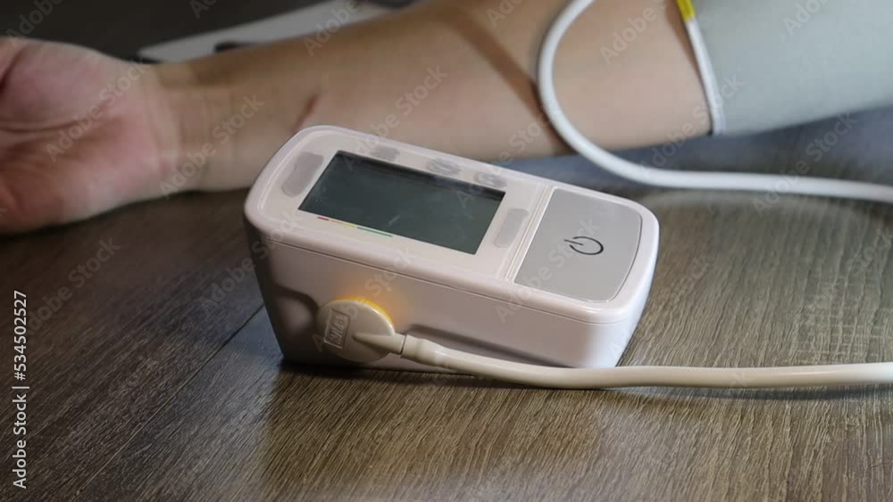 The girl measures blood pressure with an electric tonometer. The concept of maintaining health and tracking blood pressure The girl measures blood pressure with an electric tonometer. The concept of maintaining health and tracking blood pressure