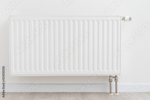 White radiator with temperature control valve. Central heating battery