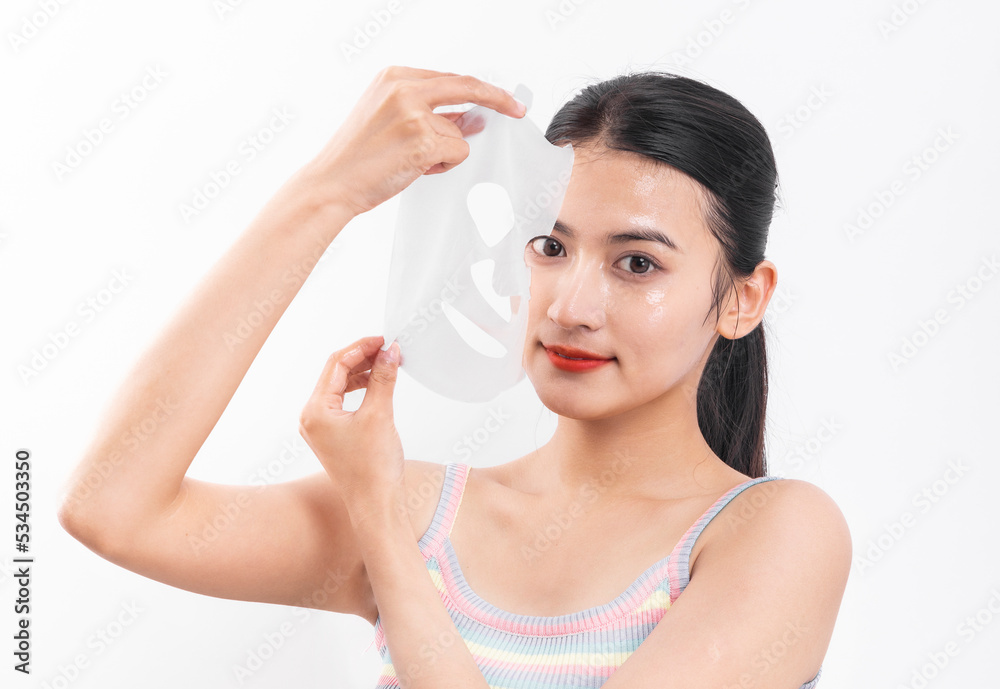 A young woman wearing a facial mask against a white background A young woman wearing a facial mask against a white background