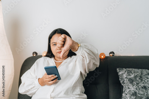 Young Asian woman using smartphone at home photo