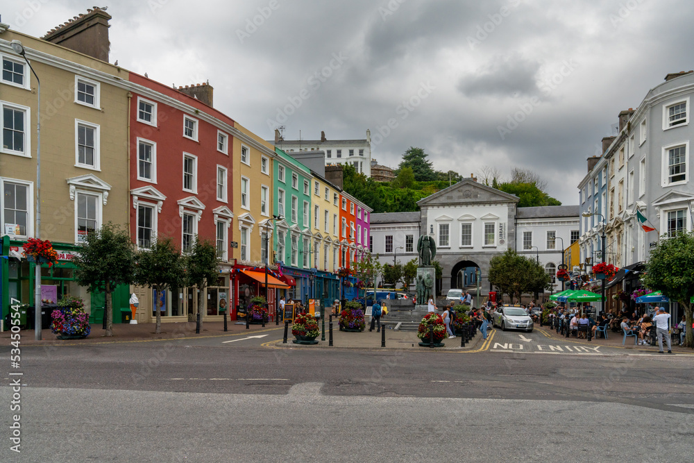 town square in Cobh with colorful houses and the Lusitania Memorial statue