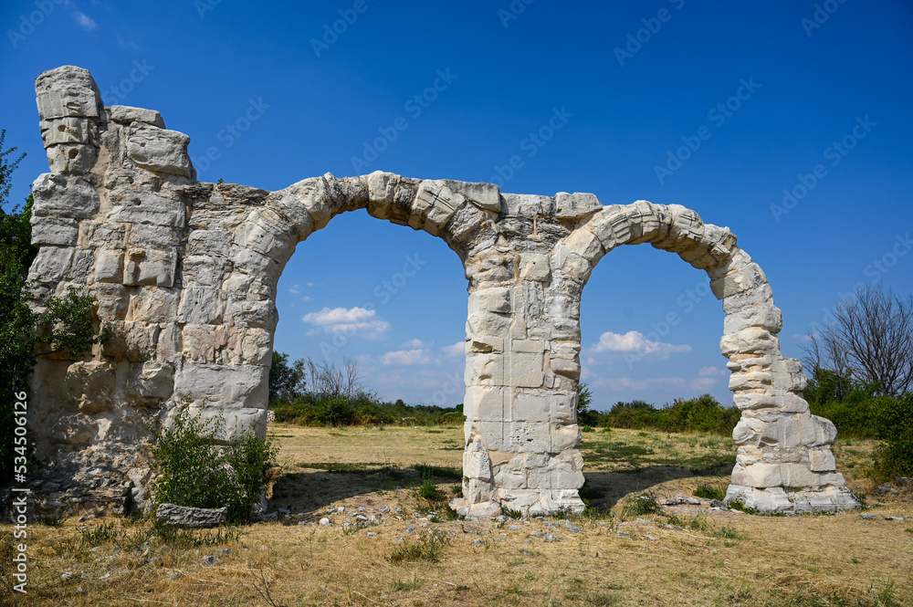 Remains of a Roman building. Old walls and arch. Burnum, archaeological site in Croatia. Former Roman Legion camp and town. 