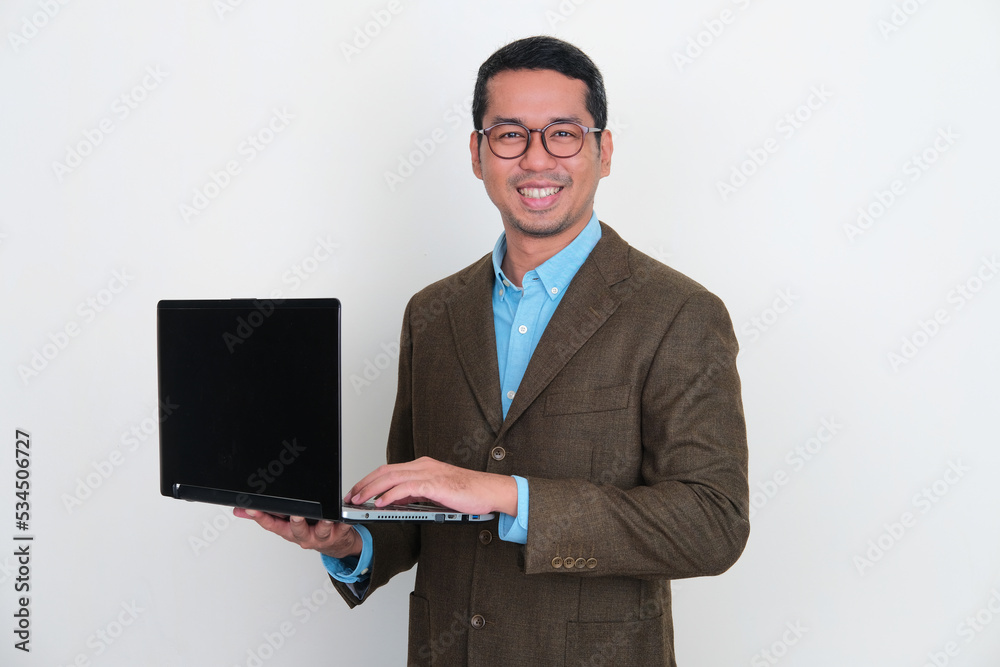Asian businessman smiling confident while working using his laptop Asian businessman smiling confident while working using his laptop