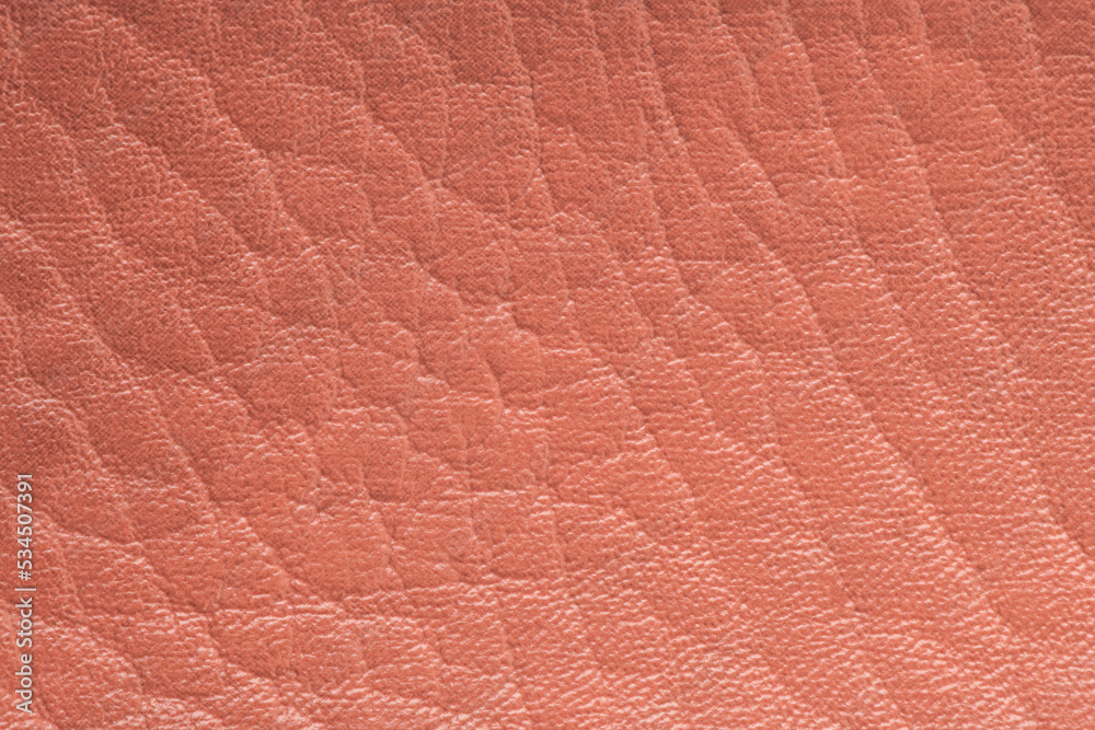 Fototapeta premium Coral color artificial or synthetic leather background with neat texture and copy space
