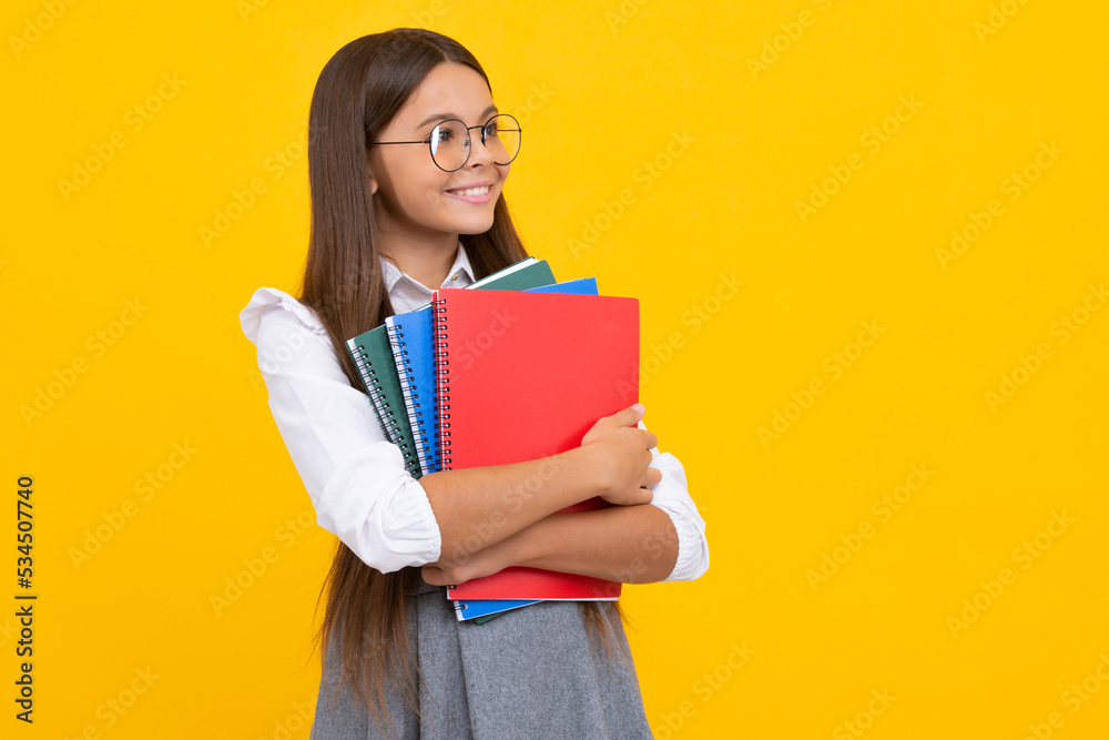 Back to school. Teenager schoolgirl with book ready to learn. School girl children on isolated yellow studio background. Happy girl face, positive and smiling emotions. Back to school. Teenager schoolgirl with book ready to learn. School girl children on isolated yellow studio background. Happy girl face, positive and smiling emotions.