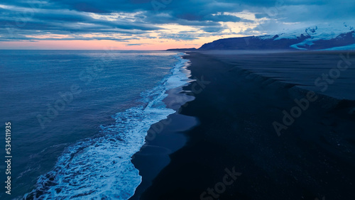 Beautiful aerial view of black beach. Sea ocean waves reaching shore.