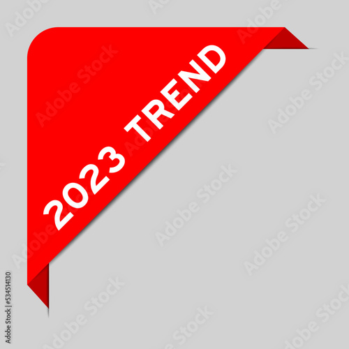 Red color of corner label banner with word 2023 trend on gray background