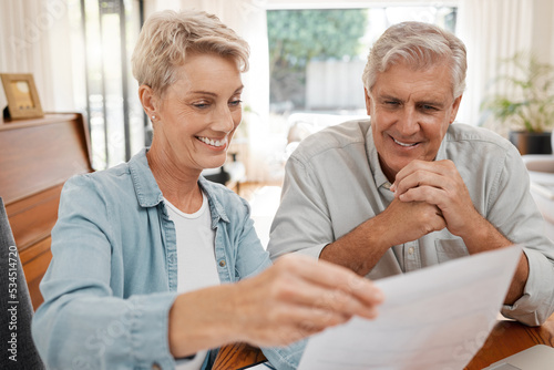 Happy couple, reading and paperwork or document for bill, mortgage or retirement plan or payout while sitting at home. Mature man and woman busy with tax compliance or finance form for pensioners