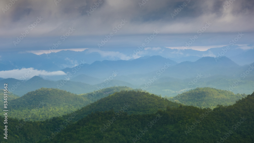 Mountain scenery in a cloudy morning with light fog.