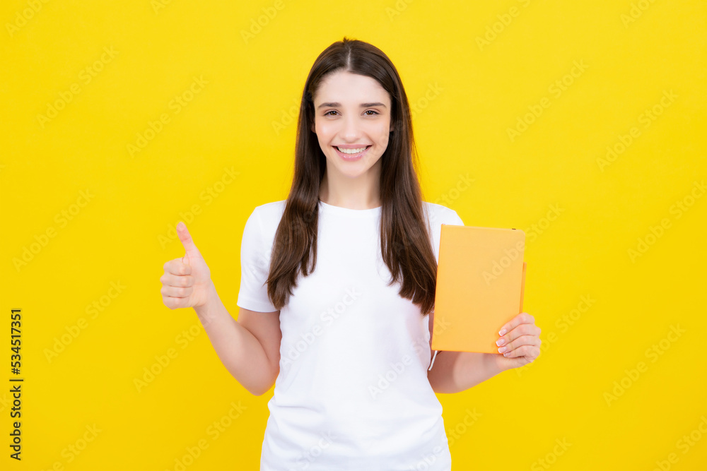 Portrait of student woman. College or high school ducation. Young woman with notebooks smiling at camera on yellow studio background. Young female university student. Portrait of student woman. College or high school ducation. Young woman with notebooks smiling at camera on yellow studio background. Young female university student.