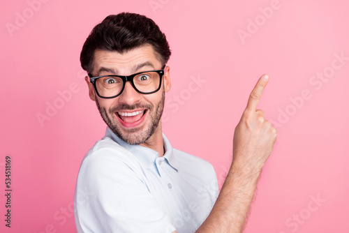 Closeup photo of young attractive handsome nice guy wear white polo t-shirt excited finger pointing empty space new proposition isolated on pink color background