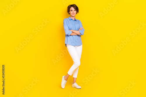 Full length photo of adorable good mood girl dressed blue shirt arms folded smiling isolated yellow color background © deagreez