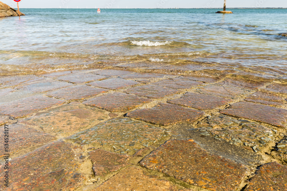 Pavés carrés et colorés d'une route submergée entre une île et le ...