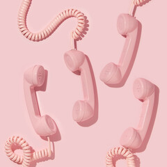 Creative layout with pink retro phone handsets on pastel pink background. 80s or 90s retro fashion aesthetic telephone concept. Minimal romantic handset idea. Valentines day idea.