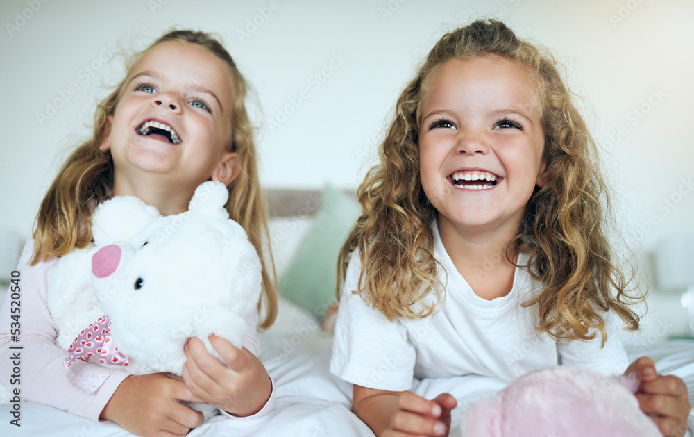 Children, teddy bear and happy sisters playing together in their bedroom at their family home. Happiness, smile and bond between twin siblings holding a toy while relaxing on a bed in their room.