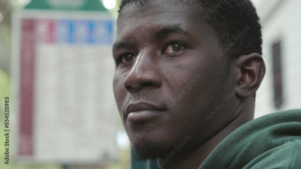 African man standing on bus stop in the city center African man standing on bus stop in the city center