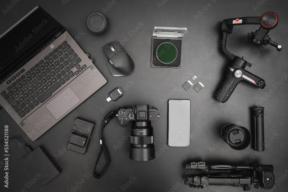 Workplace top view of videographer setting with laptop, camera, gimball, tripod, lens, batteries. Top view Workplace top view of videographer setting with laptop, camera, gimball, tripod, lens, batteries. Top view