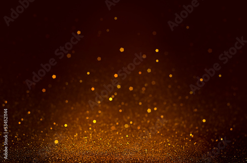 particles on a dark brown background. glitter background