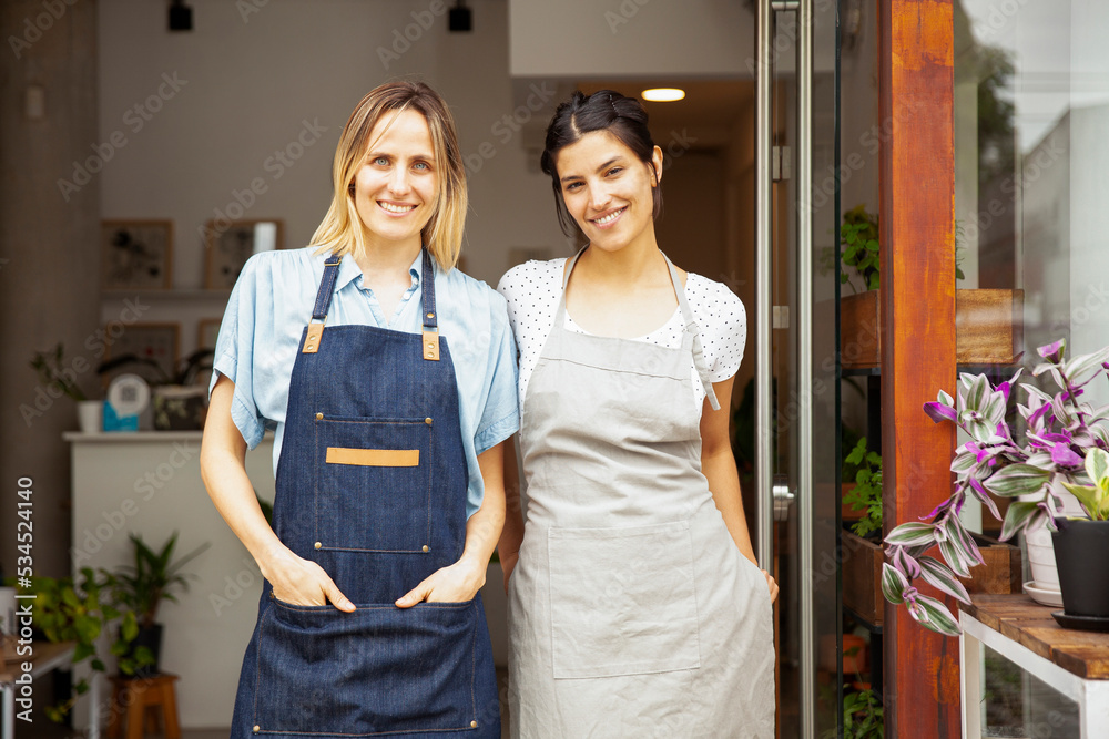 Flower shop coworkers standing at store entrance Flower shop coworkers standing at store entrance