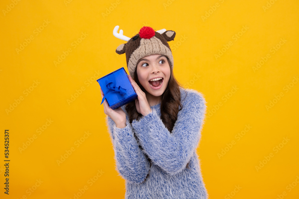 Child with gift present box on isolated background. Presents for birthday, Valentines day, New Year or Christmas. Excited face, cheerful emotions of teenager girl. Child with gift present box on isolated background. Presents for birthday, Valentines day, New Year or Christmas. Excited face, cheerful emotions of teenager girl.