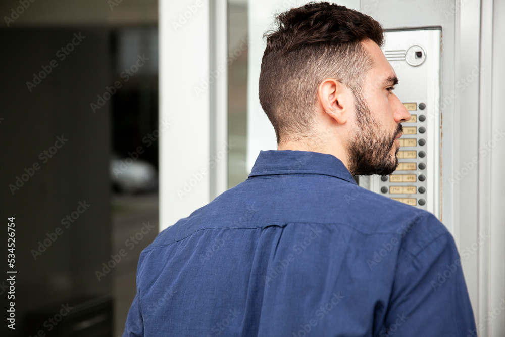 Delivery man standing in doorway while waiting to be attended Delivery man standing in doorway while waiting to be attended