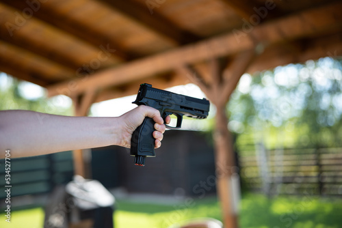Fotografija Unrecognizable woman holding and aiming a black air bb gun