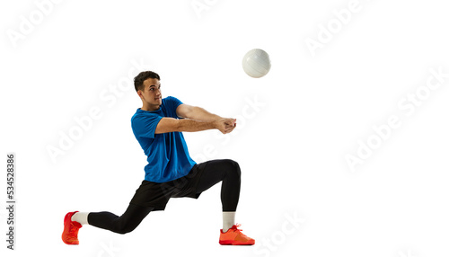 Studio shot of young man, volleyball player playing volleyball isolated on white studio background. Sport, gym, team sport, challenges © master1305