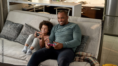 Obraz na plátně Joyful son and smiling father playing video game
