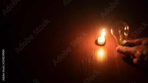 light bulb and candle on black background
