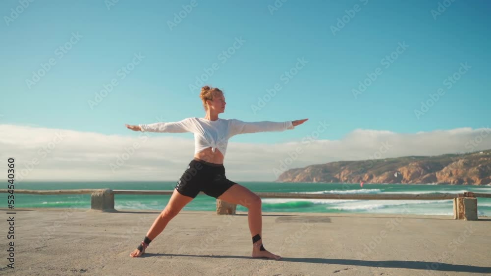 Yoga exercises with ocean view on background. Caucasian fit woman doing yoga training on seashore. Healthy lifestyle concept. Mid adult female practicing yoga and flexibility training on nature. Yoga exercises with ocean view on background. Caucasian fit woman doing yoga training on seashore. Healthy lifestyle concept. Mid adult female practicing yoga and flexibility training on nature.
