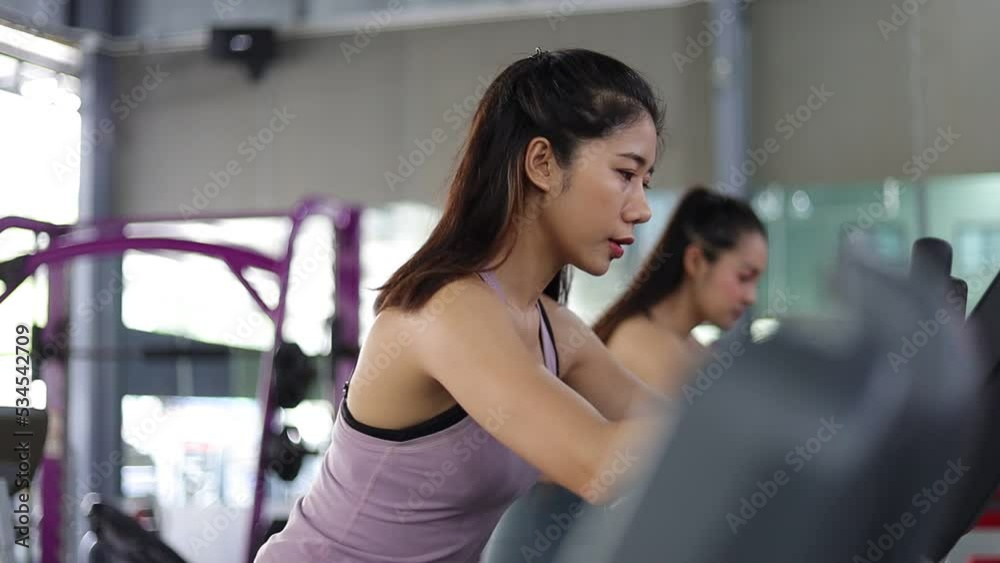 Beautiful Asian woman exercising on a bicycle at the gym. Fitness and healthy lifestyle concept. Beautiful Asian woman exercising on a bicycle at the gym. Fitness and healthy lifestyle concept.