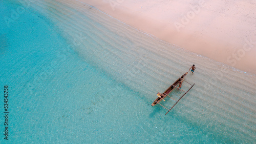 The boat is between the gradations of white sand and clean blue sea. Location in Pasir Purih Manokwari, West Papua Province