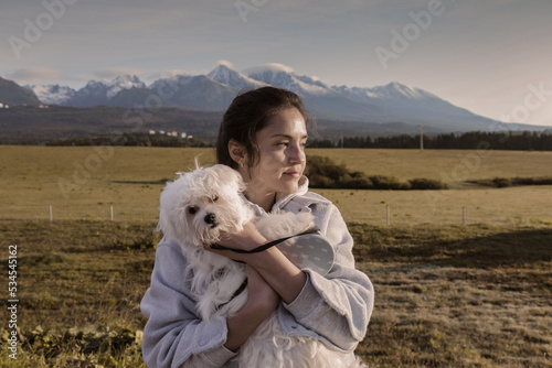 A girl with a small dog on the background of a mountain. Tatra Mountains.