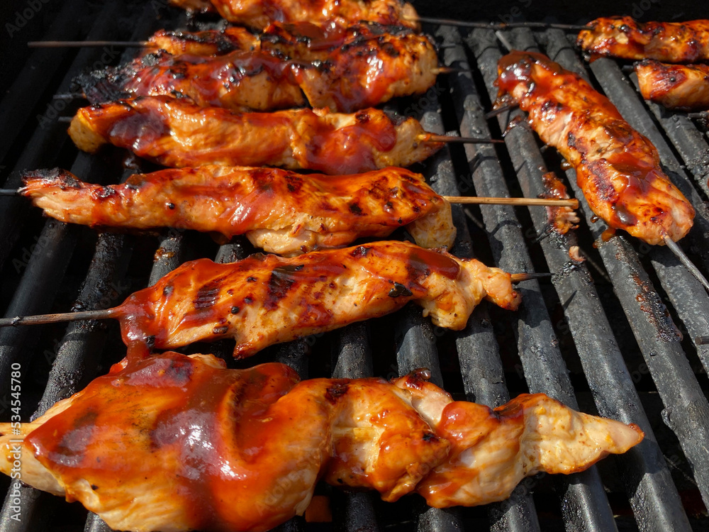 Barbecue turkey tips on a hot grill with sauce and grill marks. Juicy sauced turkey tip skewers being barbecued on the grill. Meat on the grill