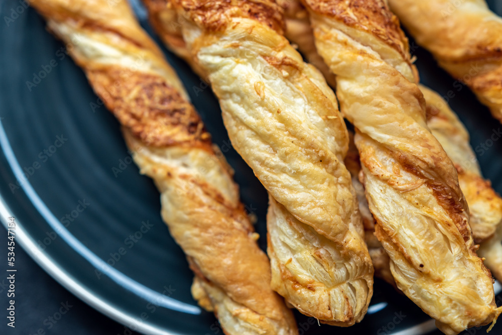 freshly baked, crispy, puff sticks on a round black plate. Perfect for a party. freshly baked, crispy, puff sticks on a round black plate. Perfect for a party.