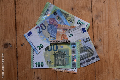 Das Wort Wohngeld mit Holzbuchstaben auf liegenden Euroscheinen photo