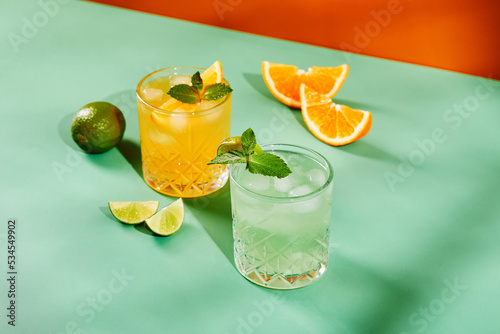 Multi-colored cocktails in glasses of different shapes on colored backgrounds with hard shadows