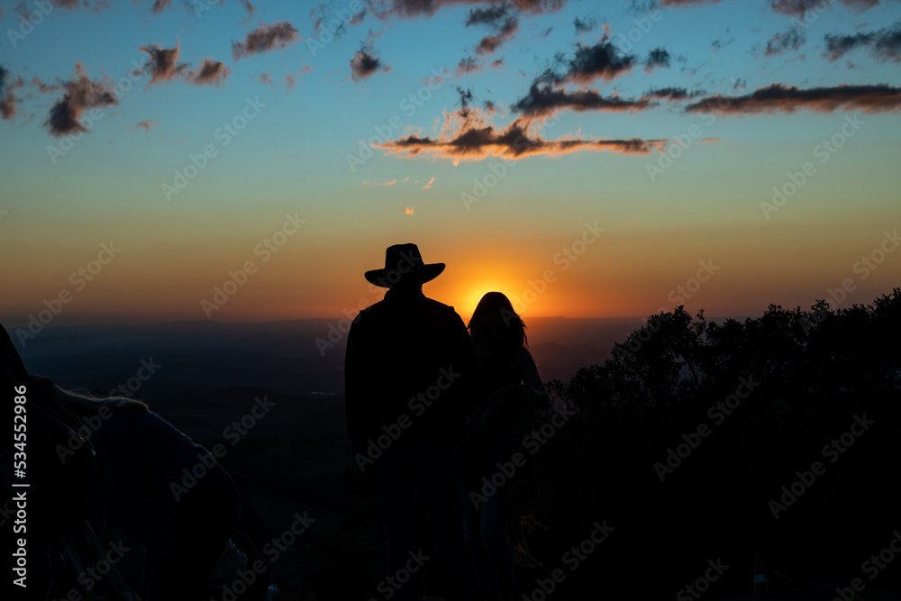 couple silhouette on mountain top at sunset