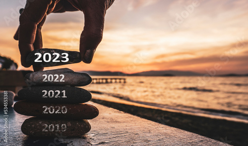 Happy new year 2023 replace old 2022. New Year 2023 is coming concept idea on orange sky. High resolution creative photo image can be used as large display, print, website banner, social media post.	
