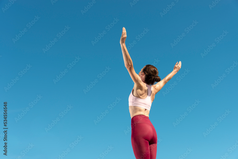 Sporty woman with arms raised in success.